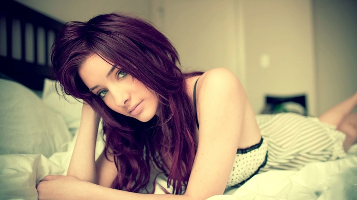 lips, green eyes, Susan Coffey, lying on front, in bed, depth of field, looking at viewer