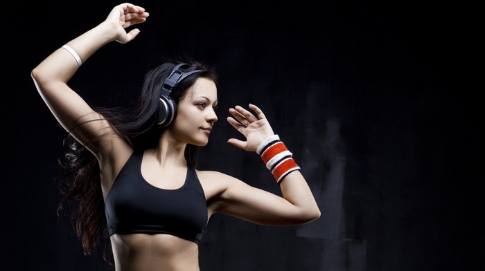 side view, dark hair, sweatband, headphones, sports bra