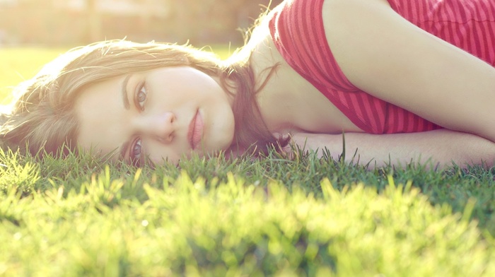 girl outdoors, grass, lying on side, sun rays, red tops, face, blue eyes