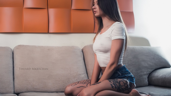 looking away, couch, girl, kneeling, brunette, jean shorts, tattoo