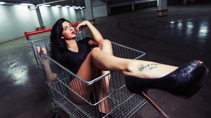 long hair, girl, tattoo, shopping cart, black clothing, finger in mouth, stiletto, dark hair, looking at viewer