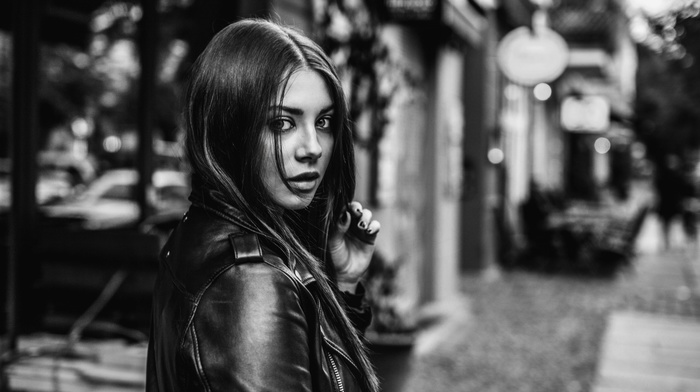 open mouth, portrait, street, looking at viewer, urban, model, hair in face, leather jackets, stores, face, long hair, depth of field, brunette, girl, girl outdoors, monochrome