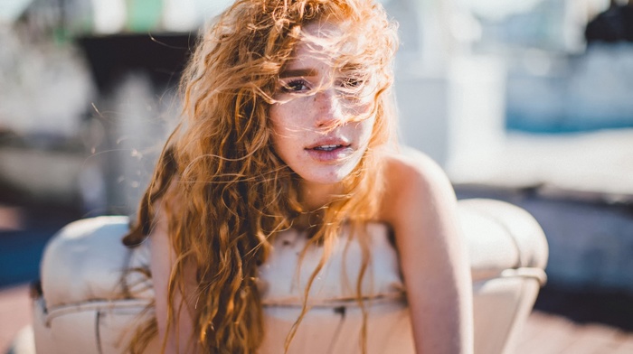 long hair, hair in face, bare shoulders, redhead, depth of field, couch, freckles, model, windy, wavy hair, looking away, open mouth, girl, curly hair