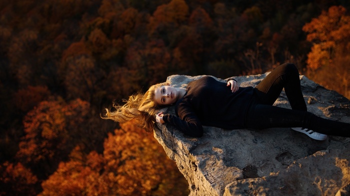 windy, looking at viewer, adidas, Skinny jeans, girl, fall, blonde, lying on back, long hair, rock, sneakers, forest, blue eyes, nature, girl outdoors, model, black clothing, trees, open mouth