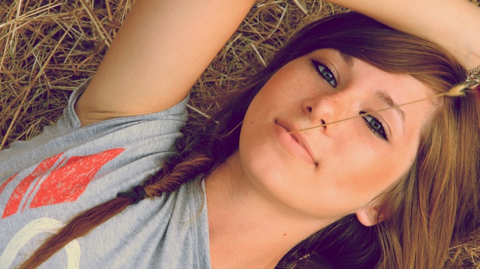 looking at viewer, face, portrait, braids, long hair, freckles, girl, hands on head, lying on back, nature, smiling, model, brunette, straw, T, shirt, spikelets, girl outdoors