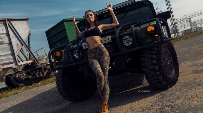 looking at viewer, camouflage, model, girl outdoors, shoes, girl, pierced navel, tattoo, Katerina Kas, pants, bra, Alex Bazilev, girl with cars