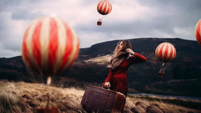 red dress, field, girl, miniatures, hot air balloons, blonde, hills, suitcase, fantasy art, looking away, windy, nature, model, long hair, girl outdoors, depth of field, photo manipulation, grass, clouds