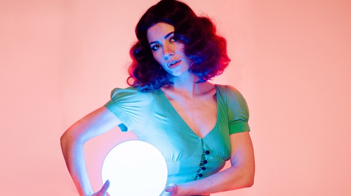 wavy hair, long hair, music, green dress, looking at viewer, girl, lights, singer, musician, open mouth, Marina and the Diamonds, brown eyes, simple background, sphere, brunette