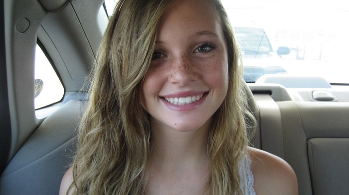 girl, back seat, smiling, looking at viewer, freckles