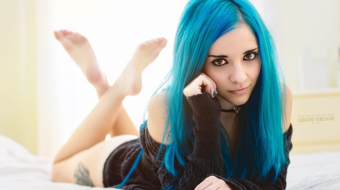 model, blue hair, nose rings, piercing, Saria Suicide, pierced nose, girl, brown eyes, lying on front, barefoot, long hair, in bed, makeup, looking at viewer, eyeliner, sweater, straight hair, Gustavo Terzaghi, legs, dyed hair