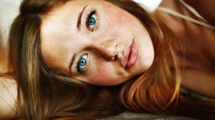 lying on side, freckles, looking at viewer, girl, blue eyes, face, brunette
