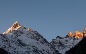 Snow-Covered Mountain Peaks Illuminated By Sunset