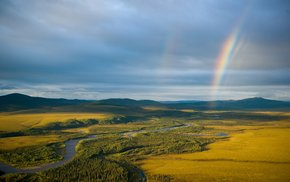 Rainbow Arch Over River And Field