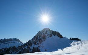 Snow-Covered Mountain With Trees And Sun